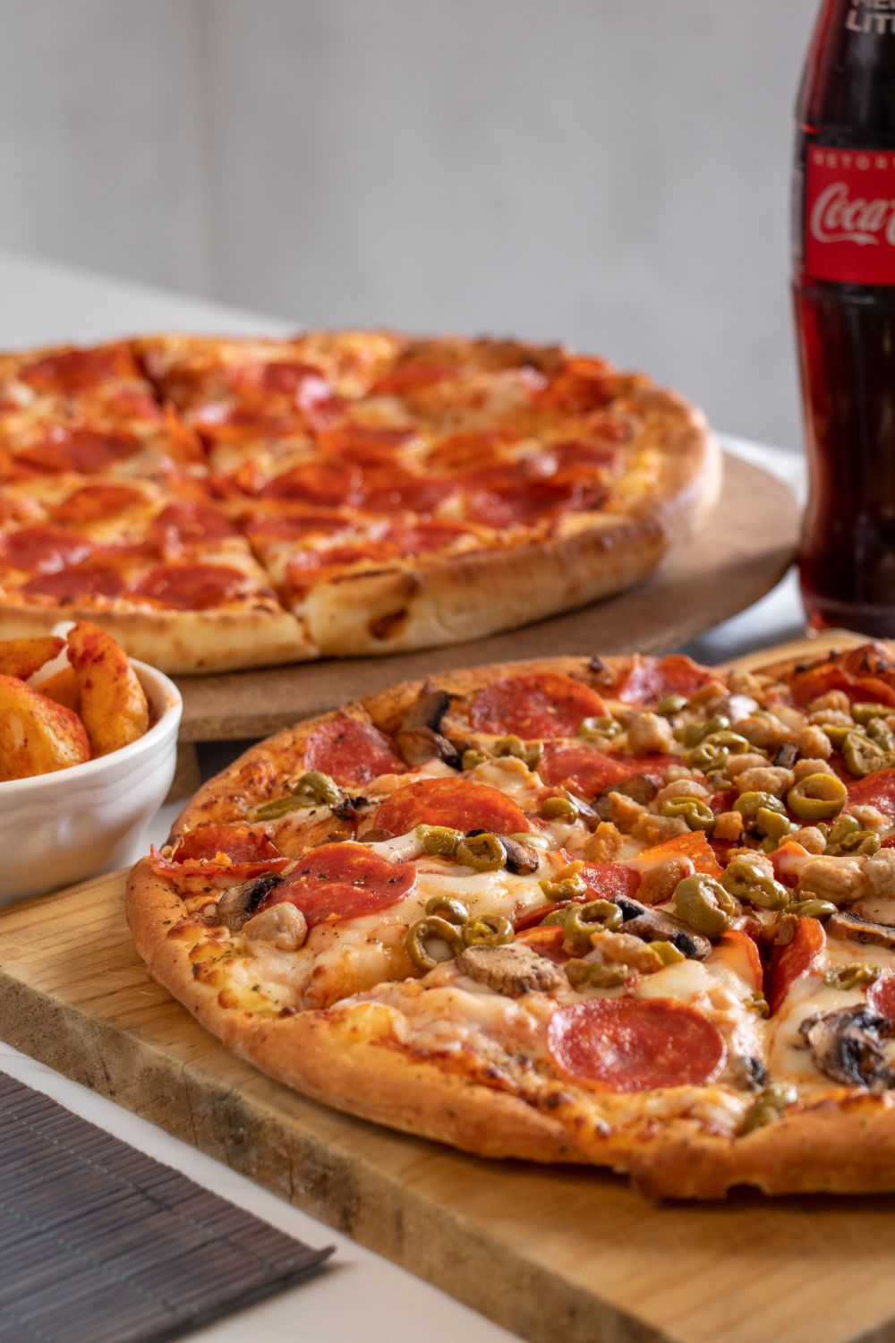 Pizze gourmet servite su tagliere di legno
